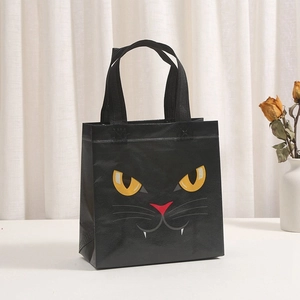 Detail of black non-woven Halloween tote bag with cute yellow cat eyes and whiskers print