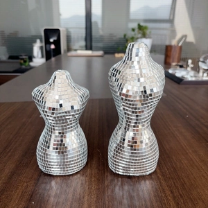 Détail de la mosaïque en miroir disco argenté sur deux sculptures de bustes féminins