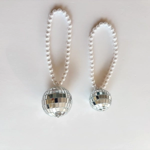 Détail macro de pendentifs boules à facettes disco avec boucles en perles blanches