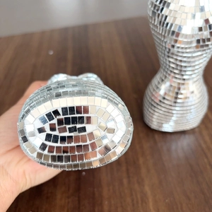 Vue détaillée d'une sculpture de buste féminin en mosaïque miroir disco argenté