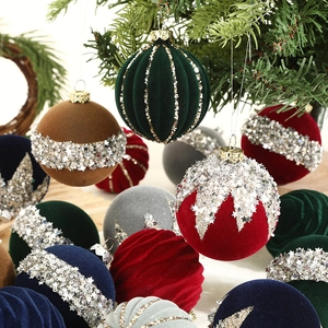 Close-up of velvet Christmas ornaments with gold glitter stripes and sequin details