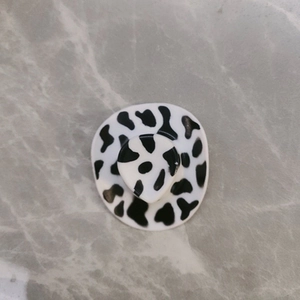 Mini cowboy hat decoration featuring a classic black and white cow print pattern on a desk