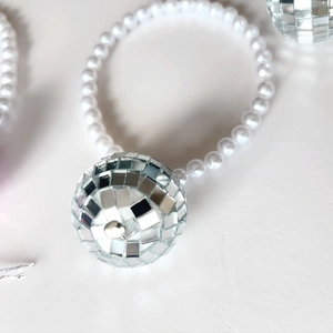 Détail d'un ornement en perles avec une boule disco argentée et un nœud élégant