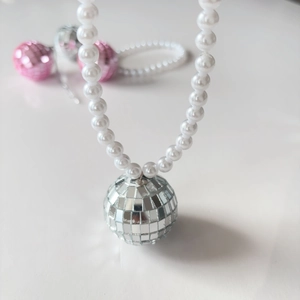 Gros plan d'un pendentif boule disco scintillant avec d'élégantes perles blanches