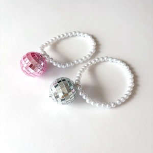 Détail des pendentifs boule à facettes disco avec perles blanches et texture mosaïque brillante