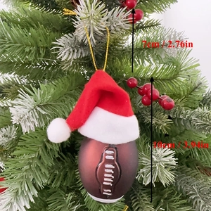 Christmas rugby ball ornament with Santa hat hanging on a festive tree with berries