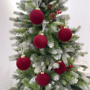 Set of 6 luxury burgundy flocked Christmas balls with gold caps on a snowy tree branch