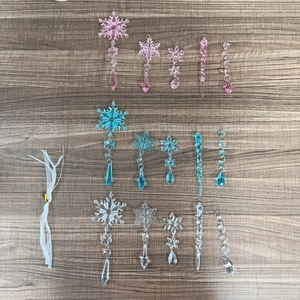Detail of acrylic snowflake and icicle pendants in pink and blue on a wooden surface