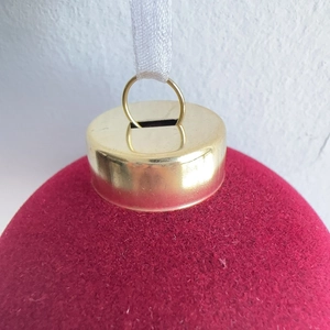 Detailed close-up of 8cm burgundy flocked Christmas ball with gold cap and white ribbon