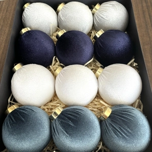 Detail of luxury velvet Christmas ball set with golden caps in a gift box packaging