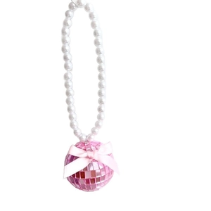 Vue détaillée du pendentif boule disco rose avec chaîne en perles et nœud en soie