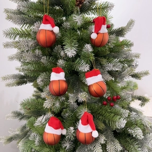 Macro shot of 6-piece basketball ornaments with mini Santa hats hanging on a Christmas tree