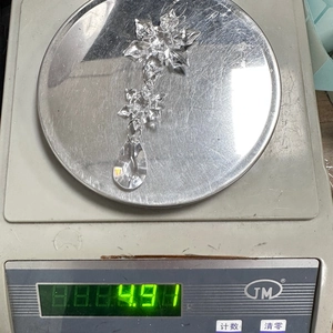 Detailed view of acrylic snowflake icicle pendant on a scale weighing 4.9g