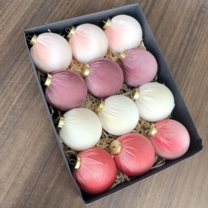 Close-up of 12 velvet Christmas balls in a luxury gift box on a dark wooden surface