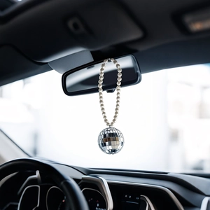 Vue détaillée du pendentif voiture boule disco avec perles suspendu au rétroviseur