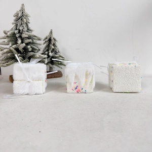 Detailed view of three white Christmas gift box ornaments with different textures
