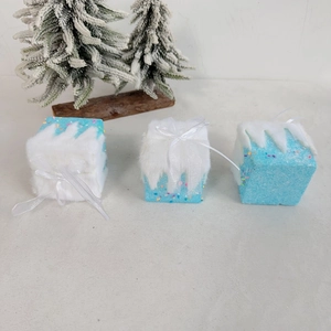 Three light blue gift box ornaments with faux fur snow and colorful confetti details