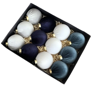 Detail of 12 velvet Christmas balls in white, navy, and grey within a black gift box