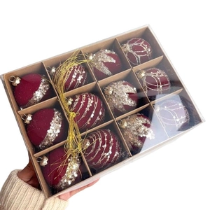 Detail of 12 burgundy flocked Christmas balls with gold glitter patterns in a gift box