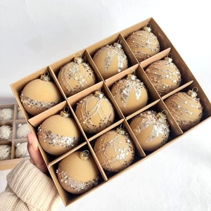 Close-up of champagne gold flocked Christmas balls with glitter stars in a kraft box