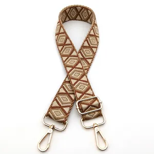 Close-up of geometric diamond pattern shoulder strap with golden metal swivel hooks