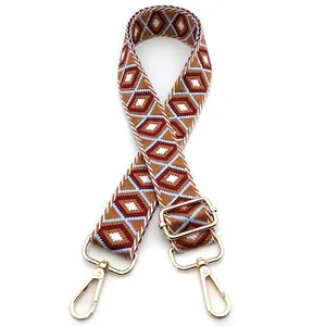Close-up of geometric diamond pattern shoulder strap with golden metal lobster clasps