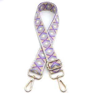 Detail of adjustable geometric diamond weave strap with gold hardware and purple tones