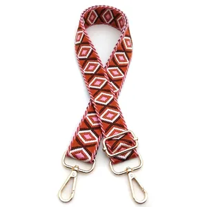 Detail view of adjustable geometric diamond pattern shoulder strap with gold metal hooks