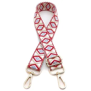 Detail of red and blue geometric diamond pattern bag strap with gold metal buckles