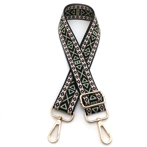 Close-up of geometric jacquard embroidered bag strap with golden metal swivel hooks