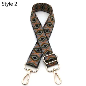 Close-up of geometric jacquard bag strap with gold metal hooks and adjustable buckle