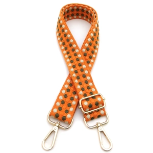 Adjustable wide woven shoulder strap in orange with green dots and gold metal hardware