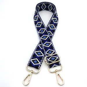 Detail of adjustable blue and black diamond pattern bag strap with gold metal swivel clips