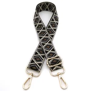 Close-up of geometric diamond weave bag strap with gold metal hooks and adjustable buckle