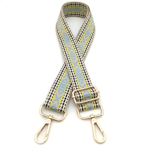 Detail of ethnic jacquard purse strap with geometric patterns and light gold hooks