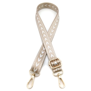 Detail of adjustable khaki arrow pattern bag strap with polished gold hardware