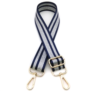 Detail of navy and silver woven bag strap with polished gold-tone lobster clasps and buckle