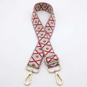 Detail of colorful geometric diamond pattern bag strap with gold metal lobster clasps