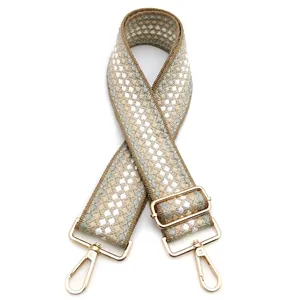 Dettaglio tracolla intrecciata larga 5cm con motivo geometrico beige e ganci in metallo oro