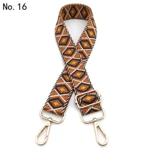 Close-up of diamond pattern woven strap with gold metal swivel snap hooks and buckle