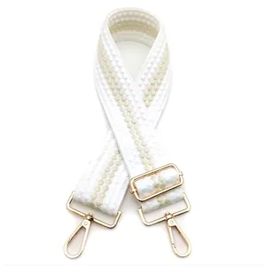 Dettaglio tracolla regolabile in tessuto da 5 cm con pois beige e ganci in metallo dorato