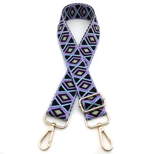 Detail of purple and green geometric diamond pattern bag strap with gold metal buckles