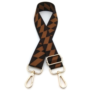 Close-up of adjustable bag strap with brown diamond patterns and gold metal buckles