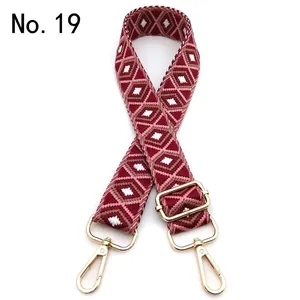 Detail view of burgundy diamond pattern woven shoulder strap with gold metal hardware hooks