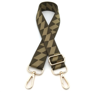 Detail of adjustable nylon bag strap featuring brown geometric diamond patterns and gold hooks