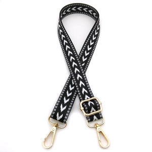 Detail of black and white herringbone woven strap with golden metal swivel hooks