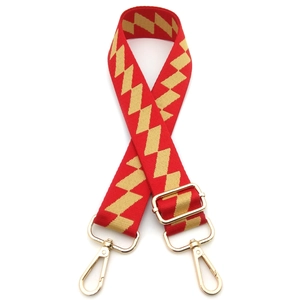 Detail of adjustable geometric diamond pattern bag strap with golden swivel lobster hooks