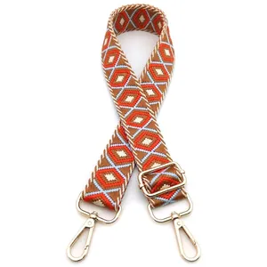 Close-up of geometric diamond pattern embroidered bag strap with gold metal hooks