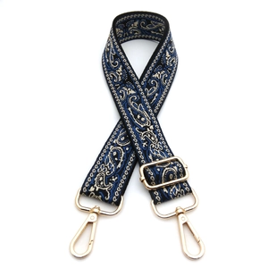 Detail of adjustable ethnic paisley jacquard strap with champagne gold rotating metal hooks