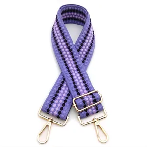 Dettaglio della tracolla tessuta viola a pois da 5cm con componenti metallici dorati